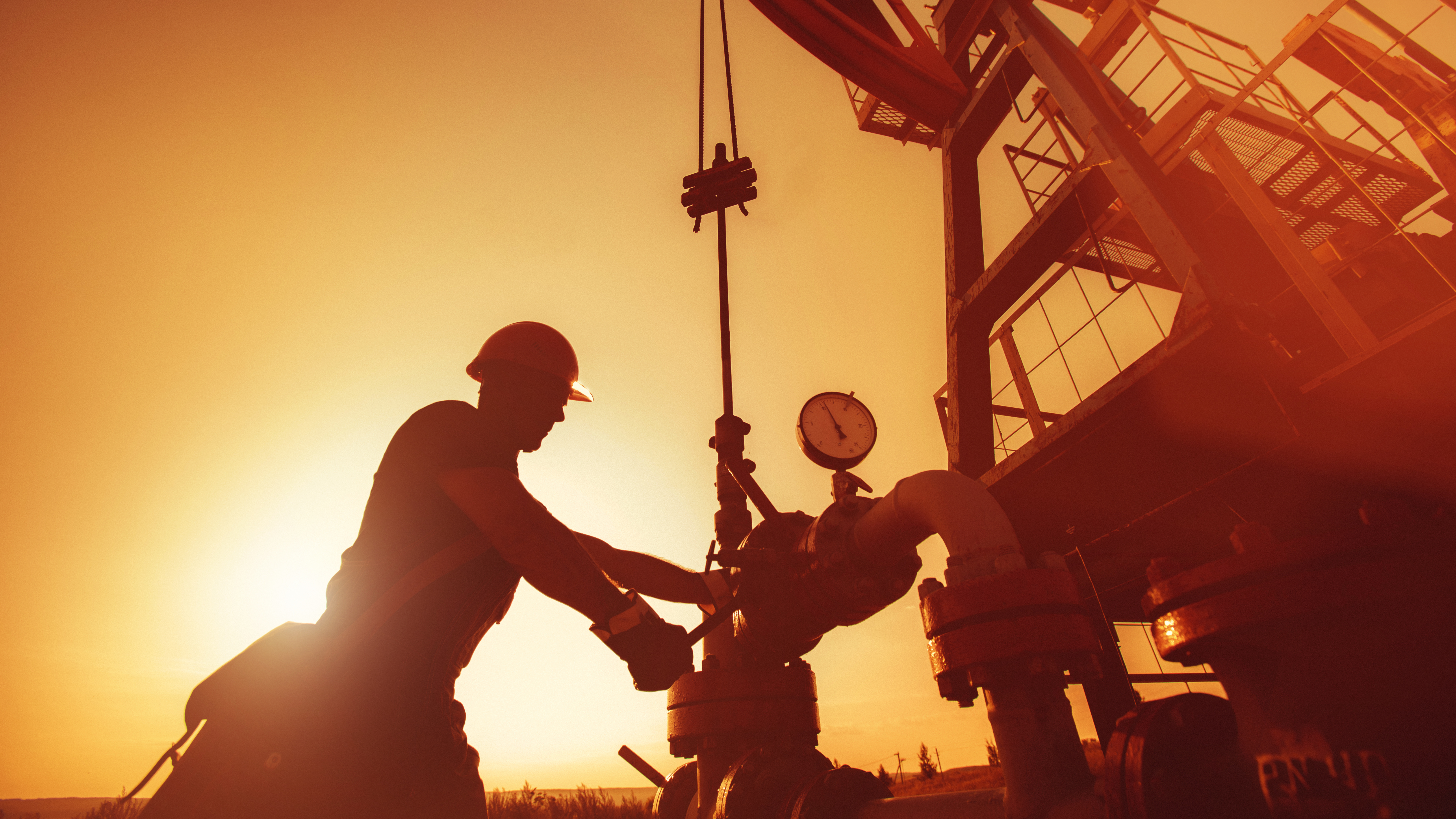 A worker drilling into the ground with a rig